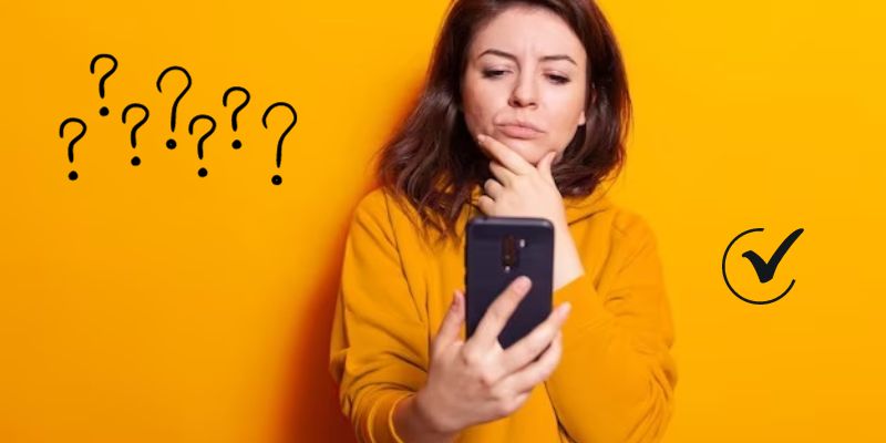 mulher com celular na mão pensando