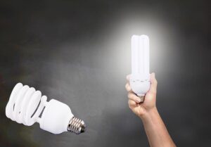 uma mão levanta uma lampada acesa