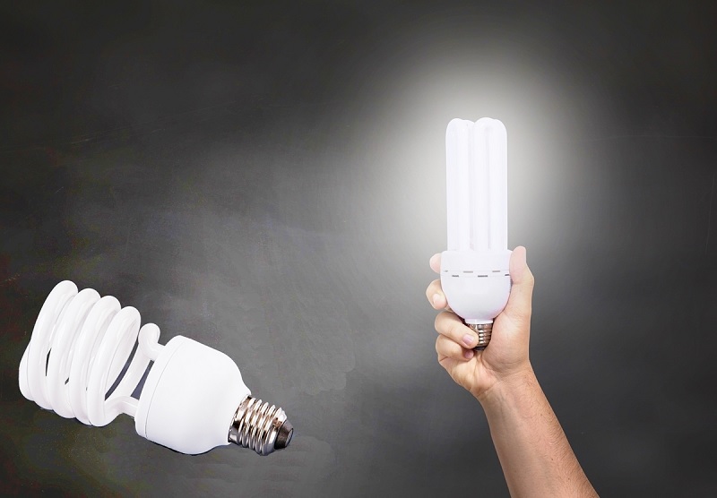 uma mão levanta uma lampada acesa