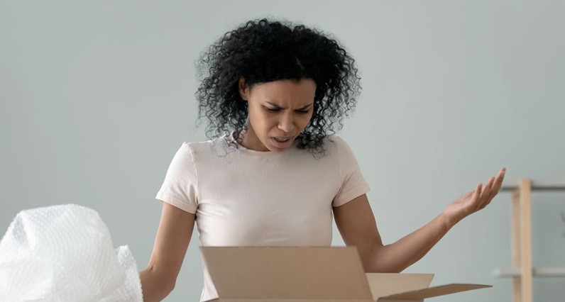 mulher abre caixa de compras e fica espantada