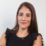 pacote de viagens comentado por Gabriela Gomes, que está de blusa preta e cabelos castanhos longos