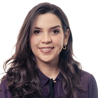 A advogada Tenylle tem cabelos escuros, longos e usa camisa preta