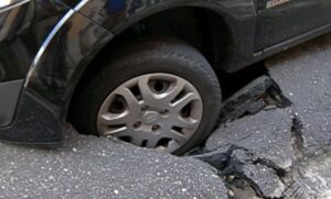 carro em buraco de asfalto