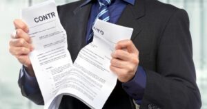 homem está rasgando um contrato com as mãos