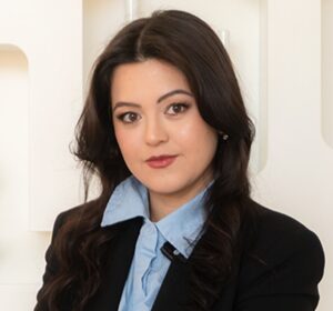 Kelfany Budel, especialista em marketing, tem cabelos pretos e veste blusa azul com blaser preto