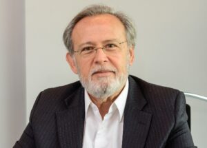 Ricardo de Barros Vieira, presidente executivo da Abecs, tem cabelos e barba grisalhos e está de camisa branca e paletó preto