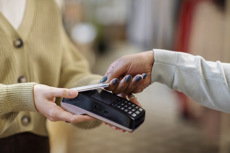 Pessoa usando cartão por aproximação para pagar compra